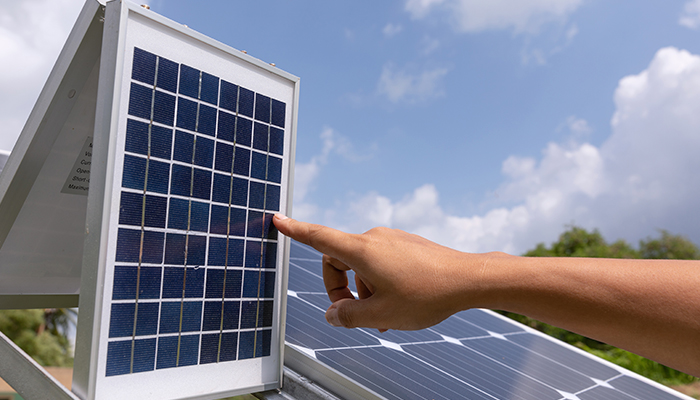 Persona señalando una casa con celdas solares. 