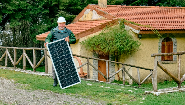 Persona poniendo su panel solar en una zona rural. Persona poniendo su panel solar en una zona rural.